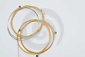 Twisted new guitar strings on white background. New acoustic guitar strings