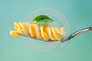 twisted pasta on a fork with a leaf.