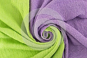Twisted textiles. Background with a wave of light green and purple towels. Background for design.