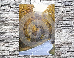 Twisting road in a window behind a stone wall