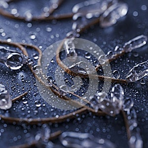 Twisting strands of brown rope are scattered across a dark blue, textured surface, photo