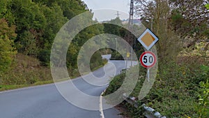 Twisty asphalt road with speed sign