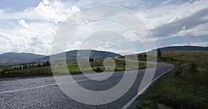 Twisty Road Sign Panning Mountain Road Time-lapse. a panning right time-lapse of a twisty road sign on the roadside with