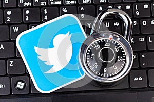 Twitter account password security simple abstract concept. Twitter service logo and a metal coded padlock, lock laying on a black