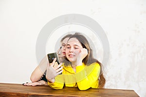 Two 15-year-old girlfriends   playing on   phone