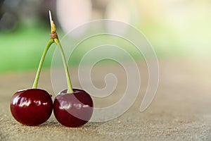 Two 2 red cherry berries with green leaf. Ripe cherries fruit macro view photo.