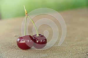 Two 2 red cherry berries with green leaf. Ripe cherries fruit macro view photo.