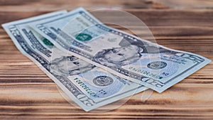 Two 20 US dollars bills lying on a burnt wooden table top