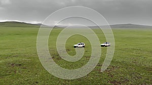 Two 4X4 Suv Cars Driving in The Treeless Vast Meadow