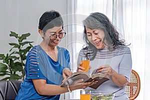 Two 60s woman enjoys talking with her friends and having a healthy food together.