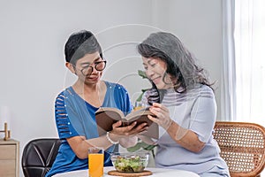 Two 60s woman enjoys talking with her friends and having a healthy food together.