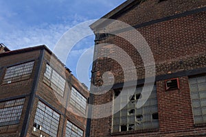Two abandoned industrial buildings against a blue sky