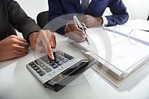 Two Accountants Calculating Tax Invoice Using Calculator