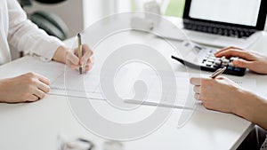 Two accountants using a calculator and laptop computer for counting taxes or revenue balance while rolls of receipts are