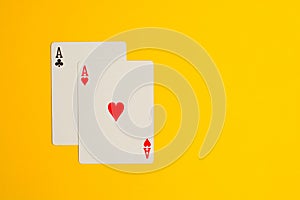 Two Ace playing cards on yellow background with copy space