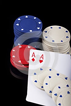 Two aces and bunch of Casino Chips isolated on black background.