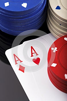 Two aces and bunch of Casino Chips isolated on black background.