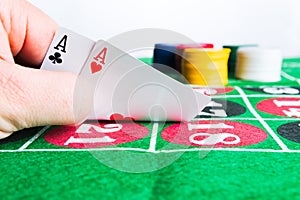 Two aces with chips on green casino table