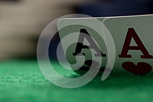 Two aces on green table with blurry chips