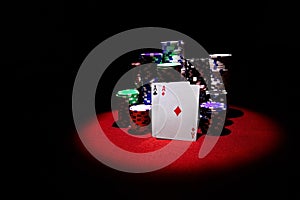 Two aces and Stack of gambling chips and dollars on red table