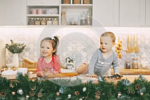 Two adorable babies play in the kitchen and help prepare holiday treats. Christmas and New year`s eve