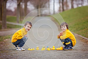 Two adorable children, boy brothers, playing in park with rubber