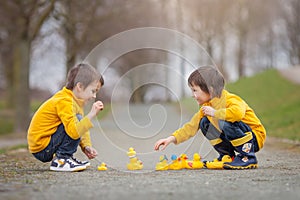 Two adorable children, boy brothers, playing in park with rubber