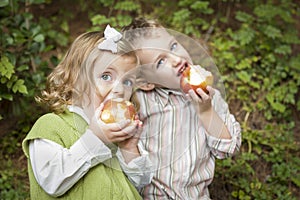 Two Adorable Children Eating Apples Outside