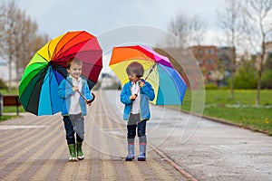 Two adorable little boys, walking in a park on a rainy day, play