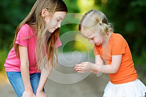 Two adorable little girl catching babyfrogs