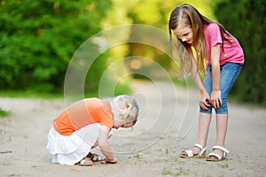 Two adorable little girl catching babyfrogs