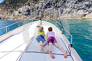 Two adorable school kid boys, best friends enjoying sailing boat trip. Family vacations on sea on sunny day. Children