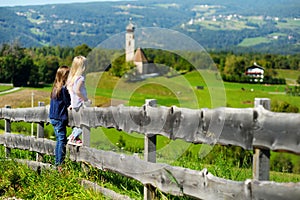 Two adorables little sisters admiring beautiful landscape in Dolomites mountain range, South Tyrol, Italy photo