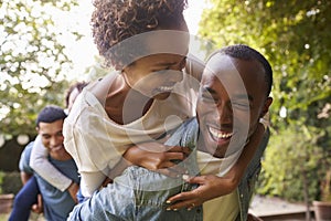 Two adult black couples piggybacking looking at each other photo