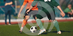 Two adult football players kicking a soccer ball in a duel. Soccer competition between two teams