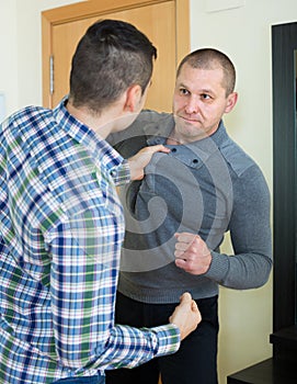 Two adult males fighting indoor