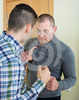 Two adult males fighting indoor
