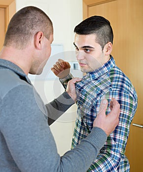 Two adult males fighting indoor