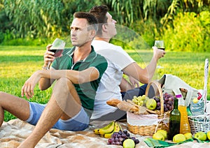 Two adult pacified brothers enjoying picnic