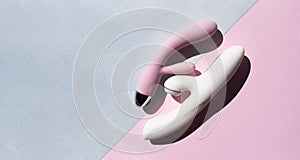 Two adult sex toys in white and pink lie on two backgrounds