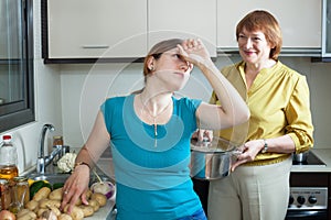 Two adult women in kitchen at home