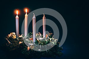 Two advent candles burning on black background