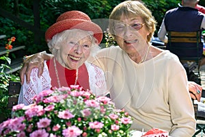 Two affectionate senior women enjoying coffee.