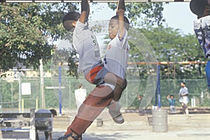 Two African-American children playing on playground equipment in Chicago, IL