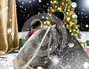 Two African American children sitting by Christmas tree