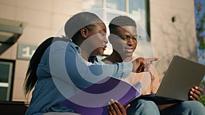 Two African American friends students high school outdoors university college building studying together classmates with