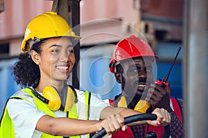 Two African American male and female worker in uniform and helmet driving and operating on diesel container forklift truck at