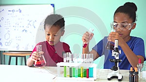 Two African American mixed kids testing chemistry lab experiment