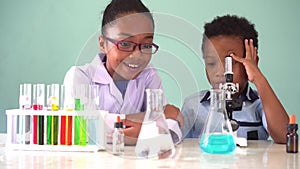Two African American mixed kids testing chemistry lab experiment