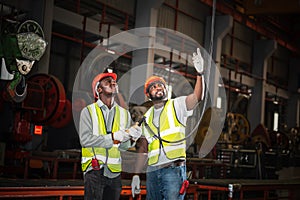 Two African American workers man, working in industry, are Standing and load crane control device is being used